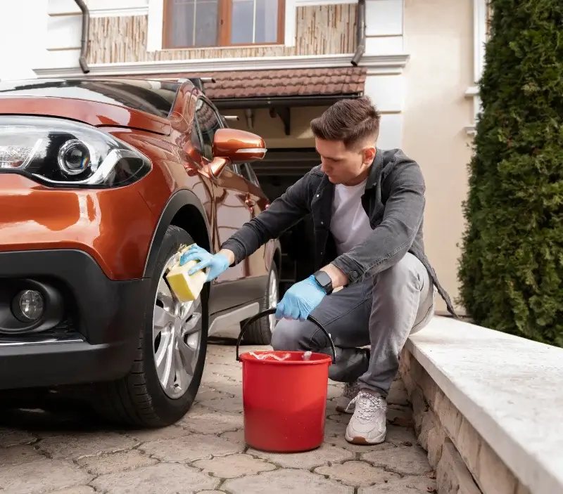 Lavage auto à domicile Montfort-l'Amaury : professionnel intervenant sur un véhicule